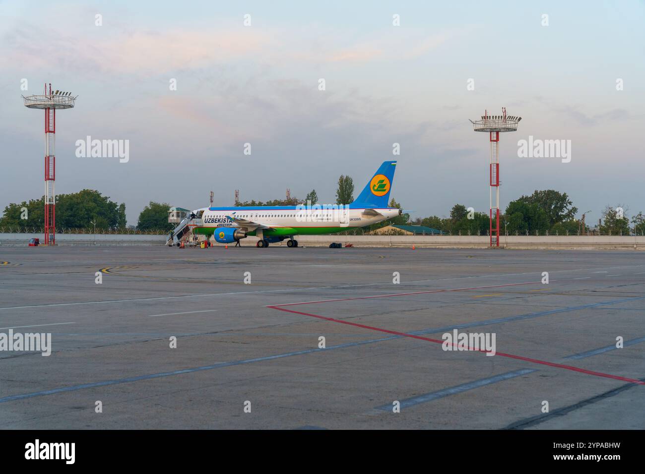 Un aereo blu e verde è parcheggiato sull'asfalto Foto Stock