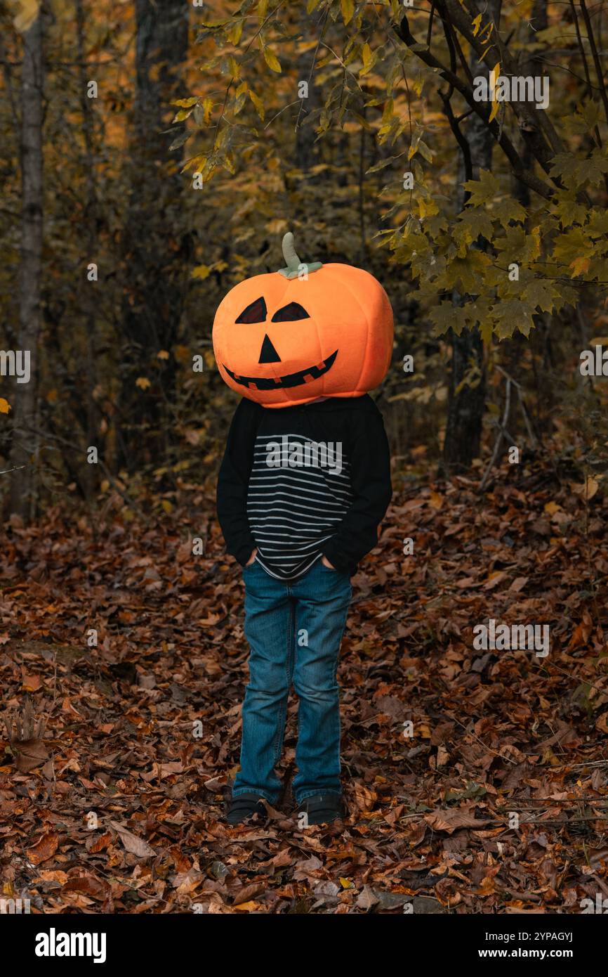 Ragazzo con una testa di zucca nel bosco Foto Stock