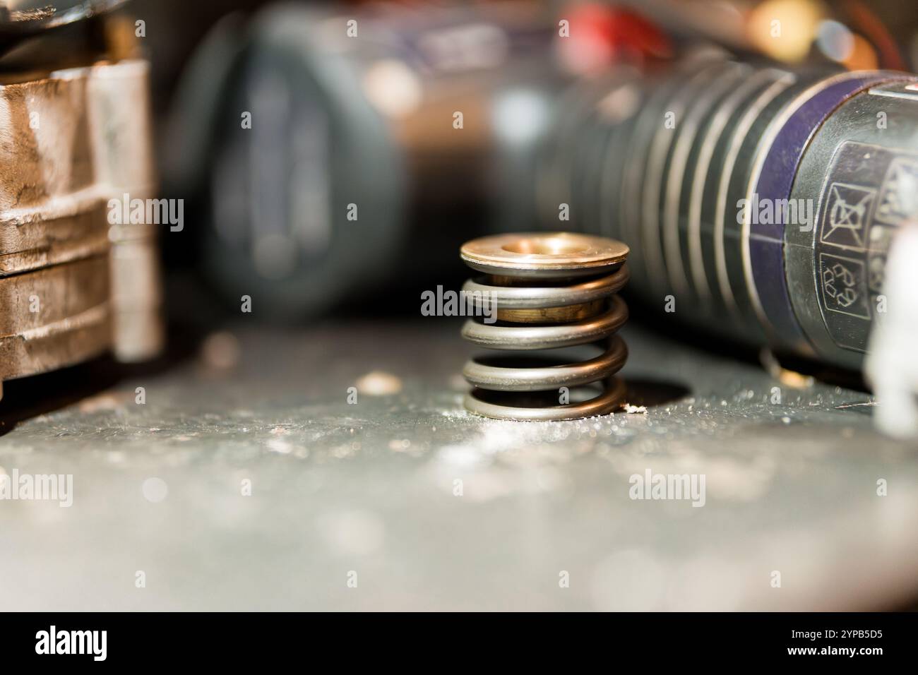 Primo piano di una pila di molle di compressione su un banco di lavoro circondato da attrezzi Foto Stock