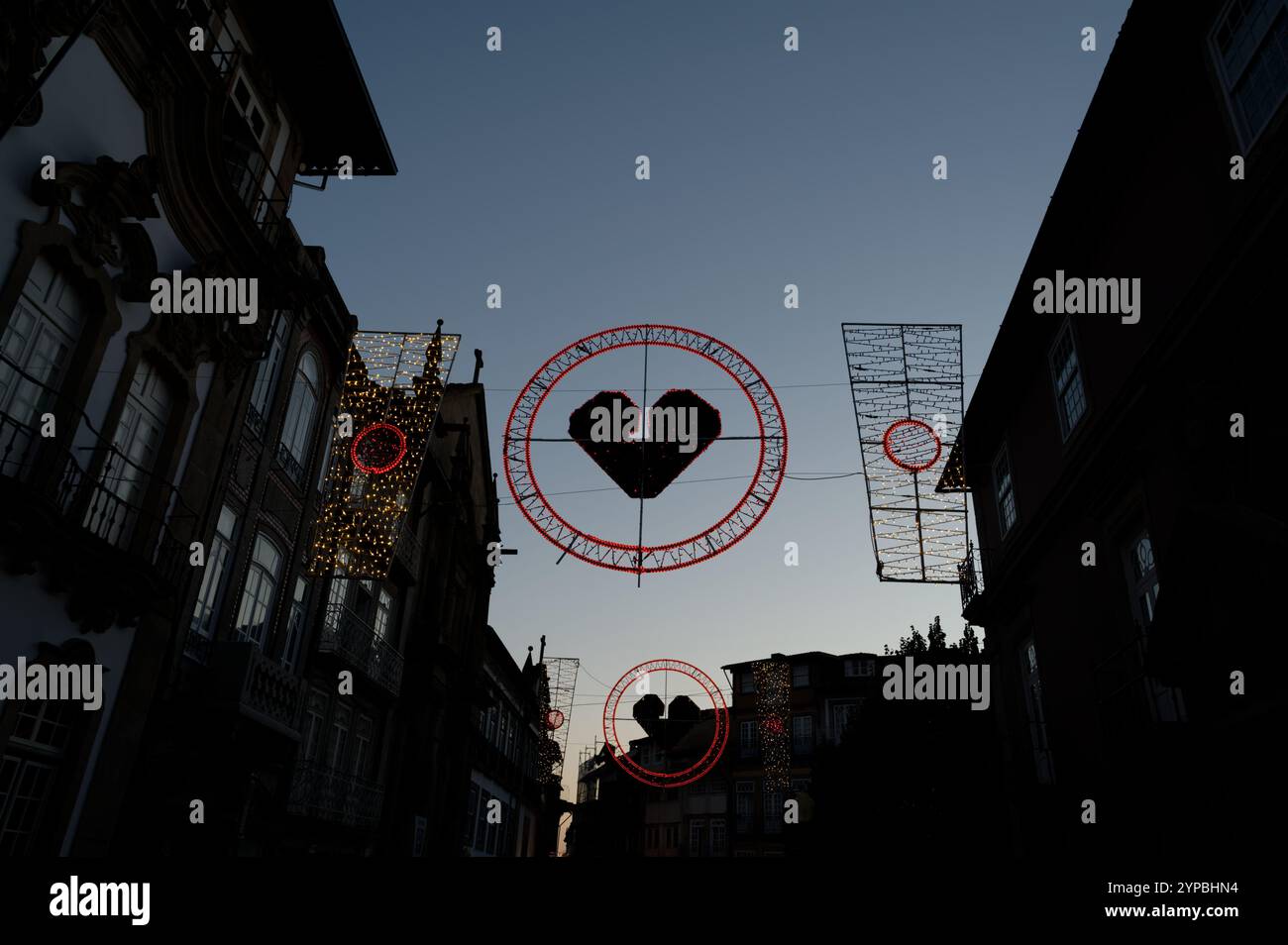 Luci decorative con design a forma di cuore durante un festival a Guimarães al crepuscolo Foto Stock