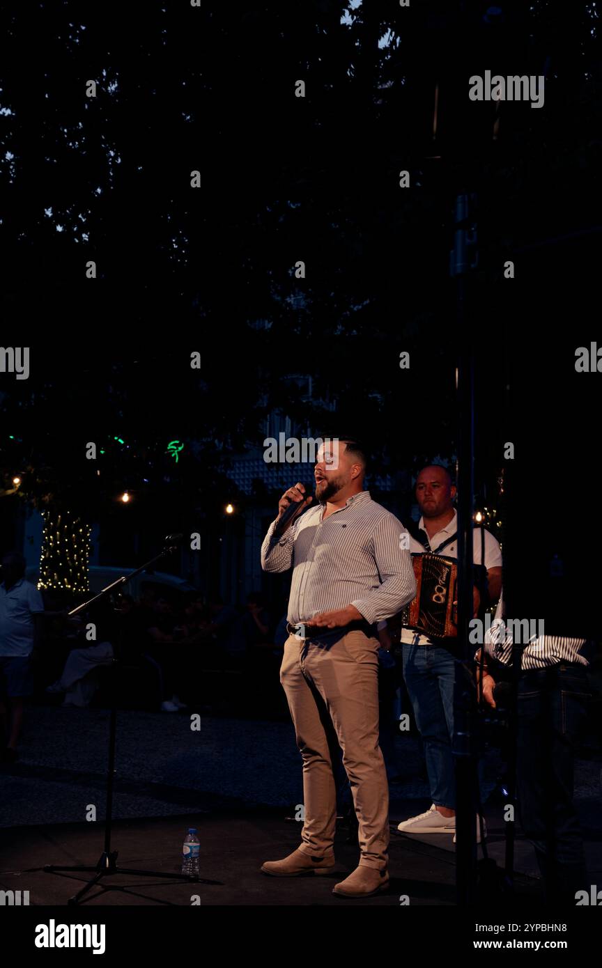 Cantante che affascina il pubblico durante una vivace esibizione ai festival della città di Guimaraes Foto Stock