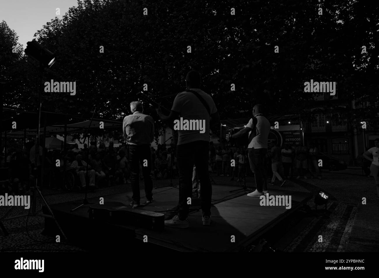 Silhouette retroilluminata di musicisti che si esibiscono ai festival serali di Braga all'ombra degli alberi Foto Stock