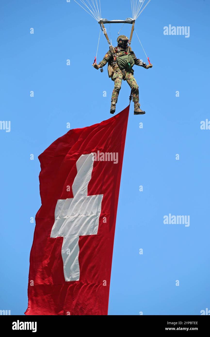 Ein Fallschirmaufklärer der Schweizer Armee an einem Freifallschirm. Er trägt die Schweizer Nationalflagge mit sich. Hochkant. Die Flugshow ZigAirMeet mit internationaler Beteiligung aus dem militärischen und zivilen Luftfahrtbereich fand AM 18. und 19. Agosto 2023 a Mollis, Kanton Glarus, Schweiz, statt. Mollis Glarus Schweiz *** paracadutista dell'esercito svizzero su un paracadutista a caduta libera che porta la bandiera nazionale svizzera sul bordo della manifestazione aerea ZigAirMeet con la partecipazione internazionale del settore dell'aviazione civile e militare si è svolta il 18 e 19 agosto 2023 a Mollis, Canton Glarus, Svizzera Foto Stock