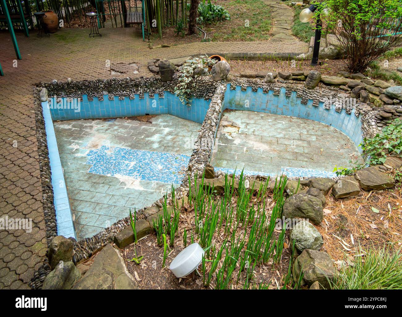 Una piccola piscina in due parti decorata con pietra naturale Foto Stock