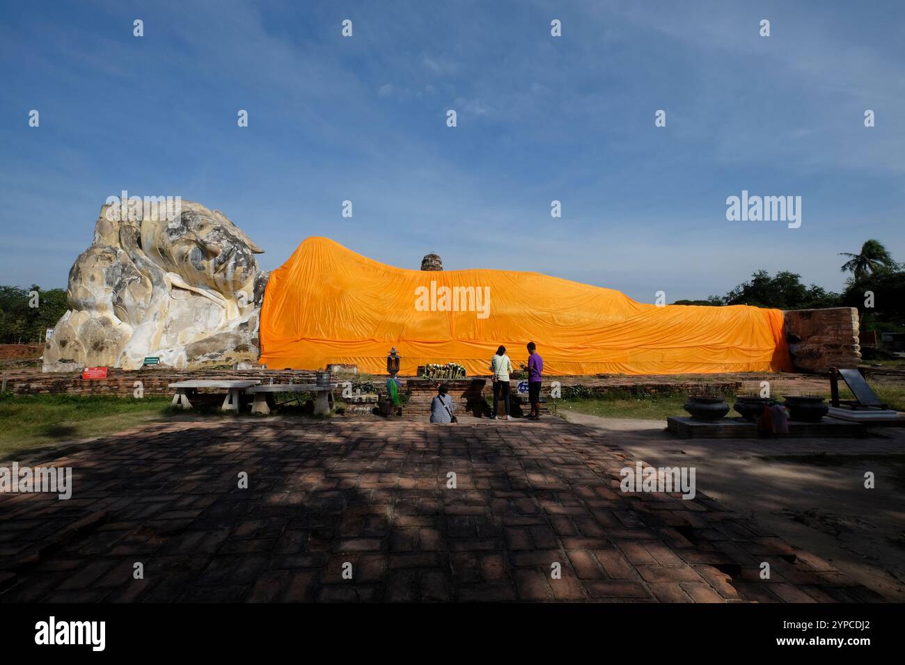 I turisti ammirano la gigantesca statua di buddha reclinata coperta da un panno arancione al tempio wat lokayasutharam di Ayutthaya, Thailandia Foto Stock
