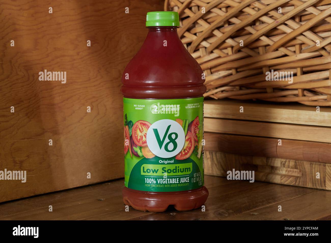 Bottiglia di succo vegetale a basso contenuto di sodio di marca V8 da concentrato, su sfondo rustico con spazio di copia Foto Stock