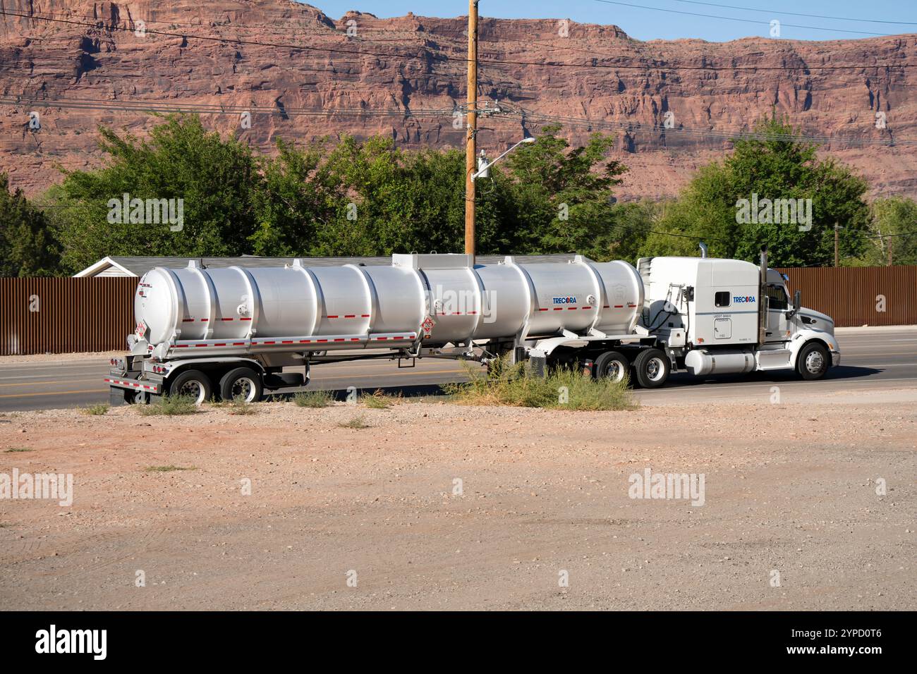 grande camion americano che tira una cisterna liquida cromata che si muove lungo un'autostrada Foto Stock