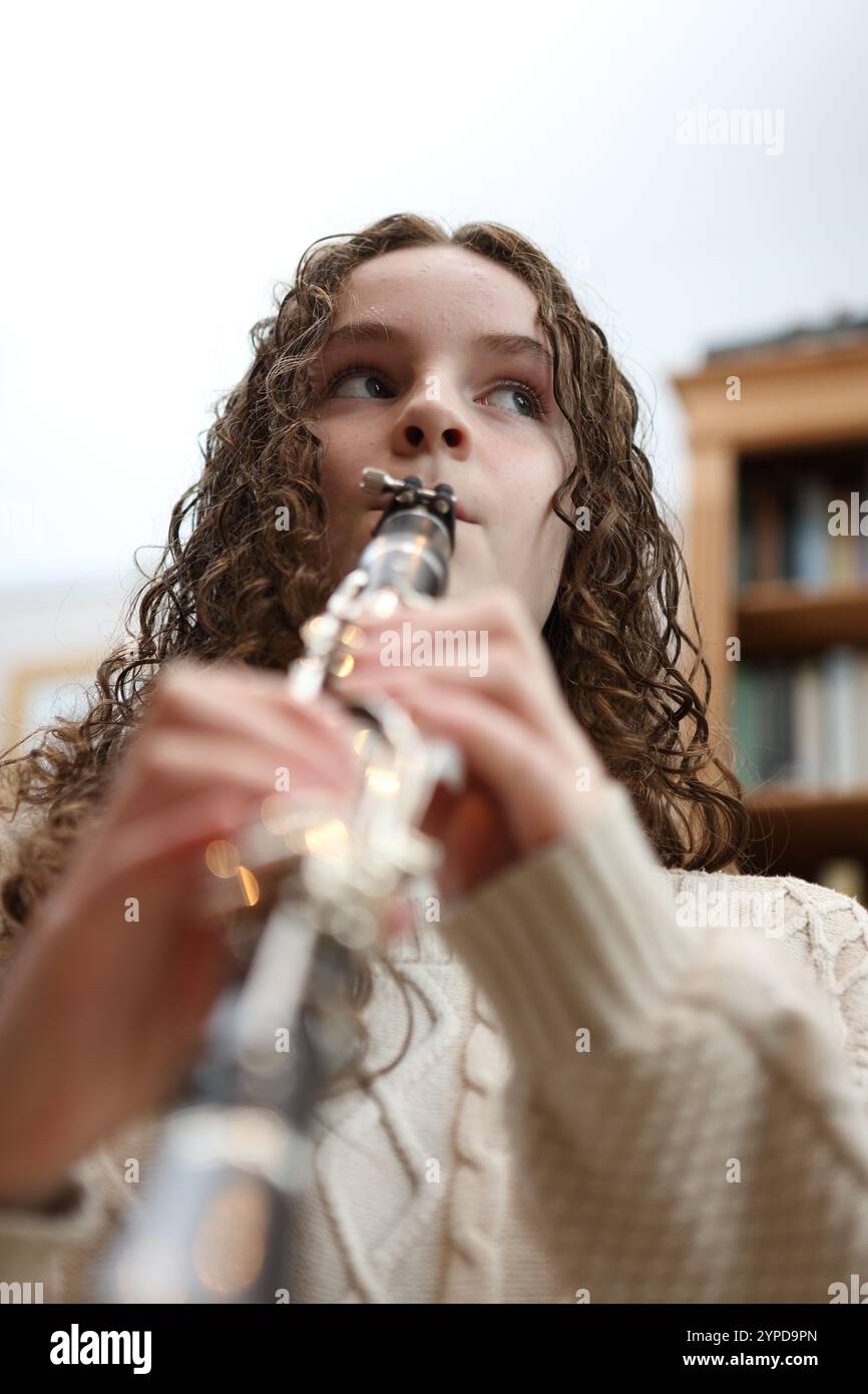 Adolescente che gioca al clarinetto in salotto Foto Stock