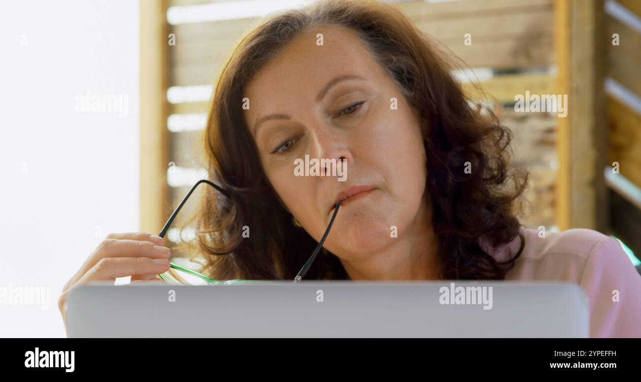 Un dirigente donna premurosa che utilizza un notebook in ufficio 4K Foto Stock