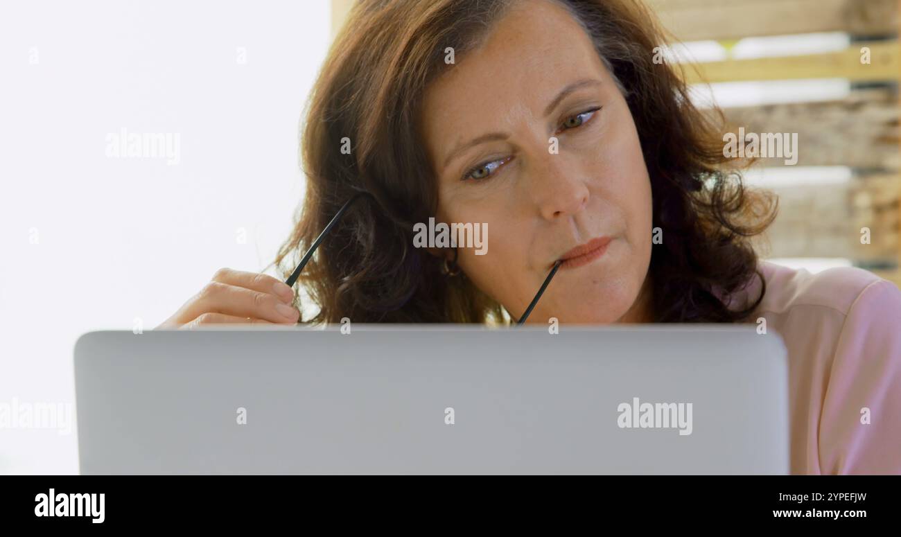 Un dirigente donna premurosa che utilizza un notebook in ufficio 4K Foto Stock