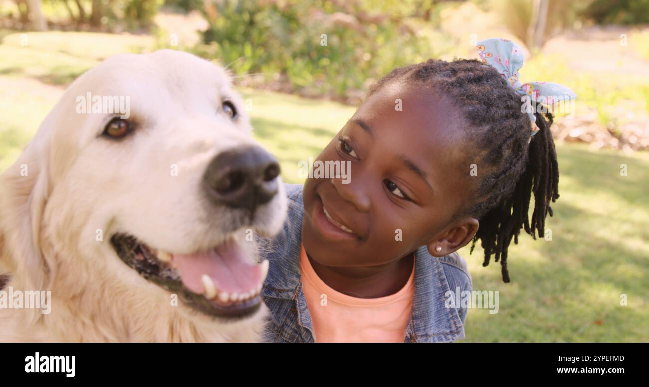 Il ritratto di una ragazza carina sta accarezzando un cane nel parco Foto Stock