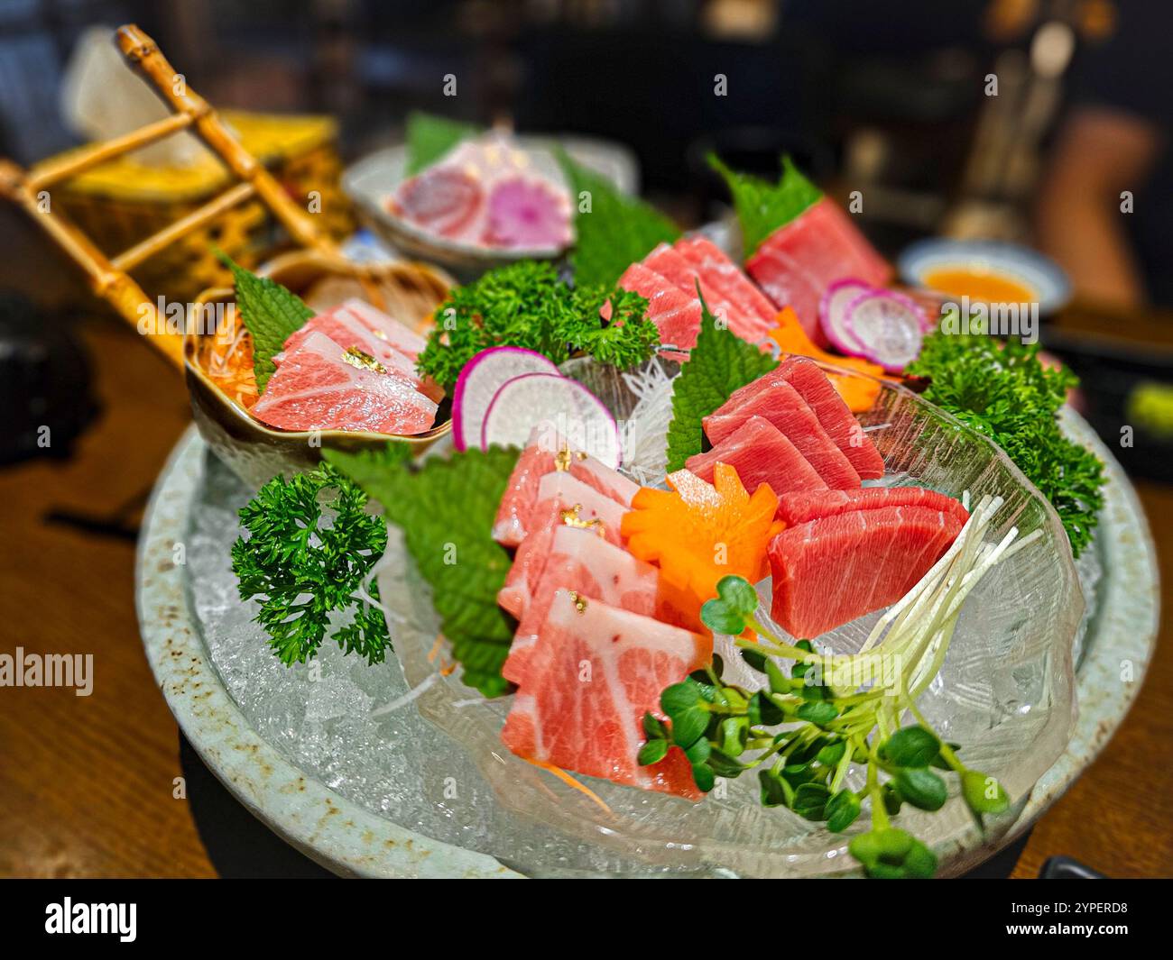 Un vassoio di sushi con una varietà di carni e verdure. Il sushi viene servito in una ciotola con un coperchio Foto Stock