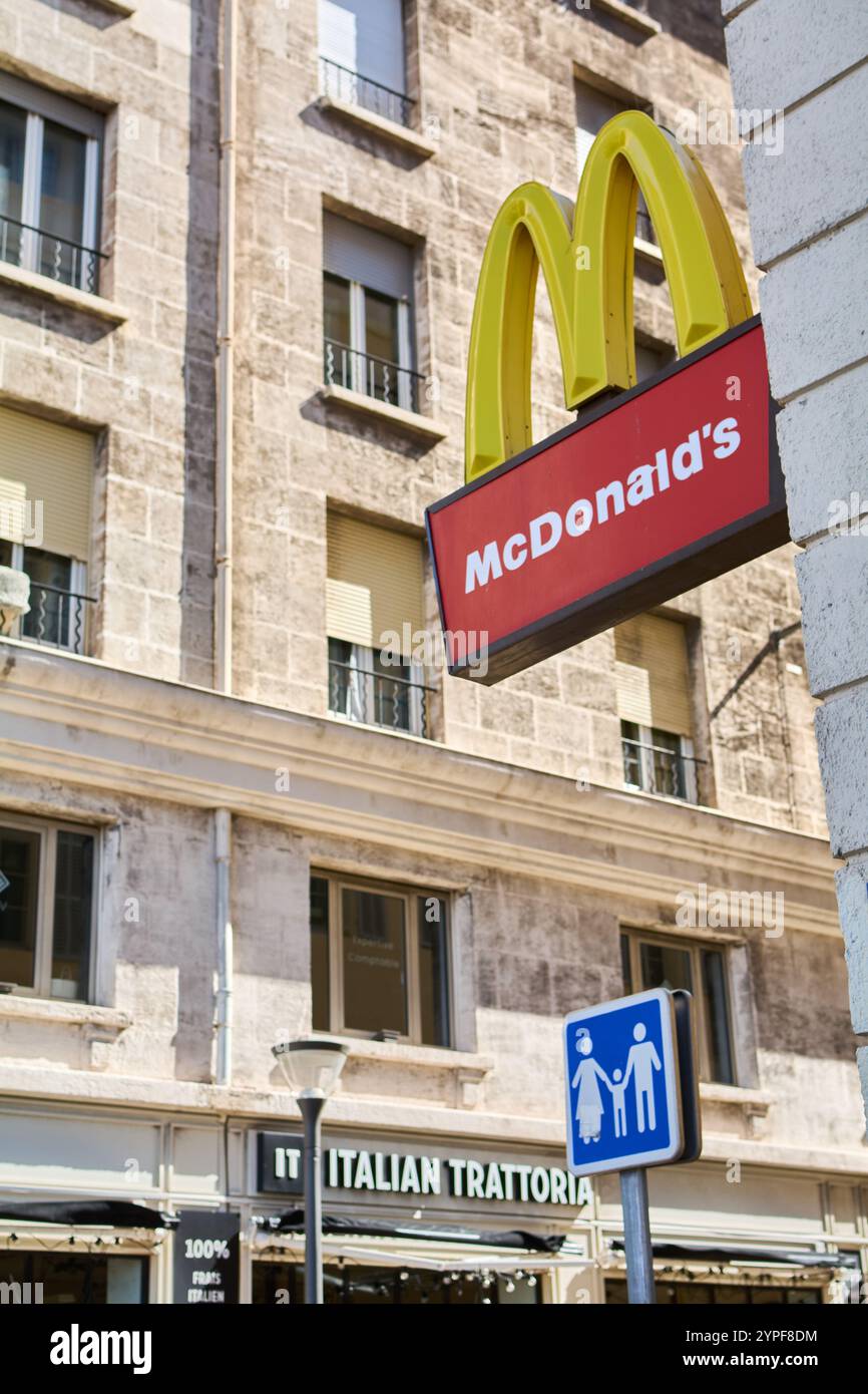 Marsiglia. Francia - 30 novembre 2024: Cartellone McDonald esposto in un ambiente urbano vicino a una trattoria italiana, che mette in risalto la variegata cucina la Foto Stock