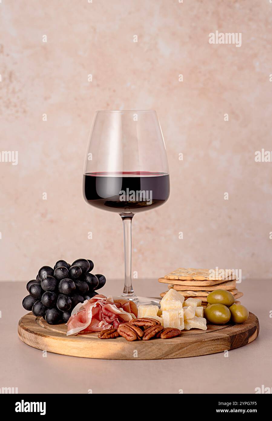 Fotografia gastronomica di vino rosso, parmigiano di formaggio, prosciutto, olive, noci pecan, uva, cracker, bicchiere di vino, assortimento, pasto per feste, spuntini Foto Stock