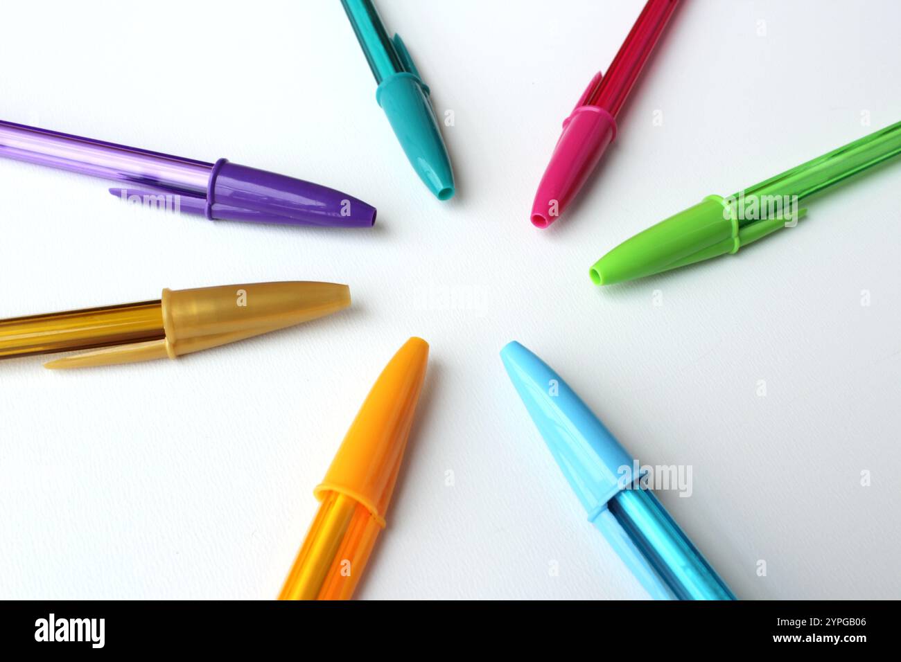 Penne colorate disposte in cerchio su sfondo bianco. Materiale scolastico di cancelleria dai colori brillanti. Creatività, arte, immaginazione. Foto Stock