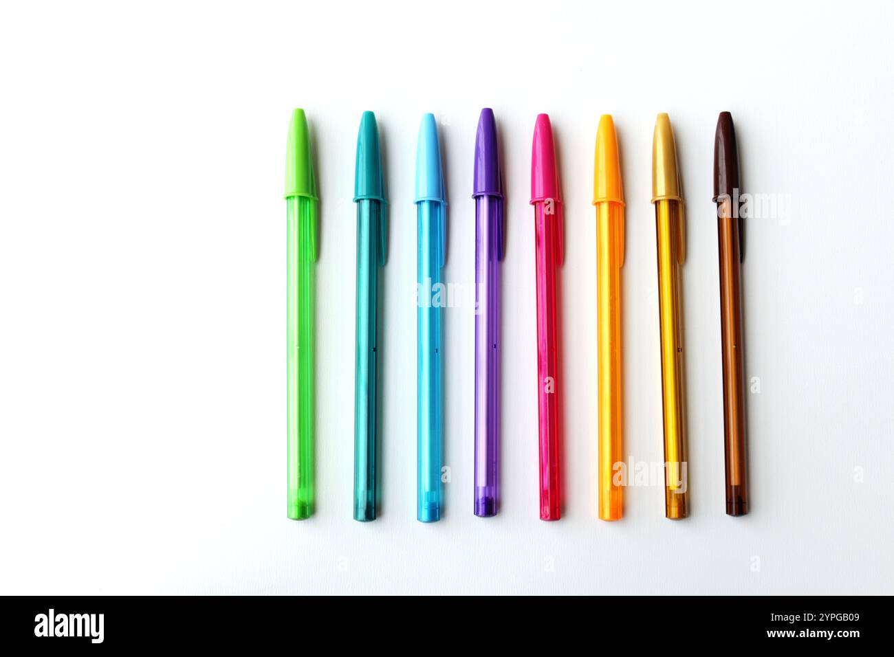 Penne colorate disposte affiancate su sfondo bianco. Colori freddi e colori caldi. Cancelleria, forniture scolastiche, concetto di creatività. Foto Stock