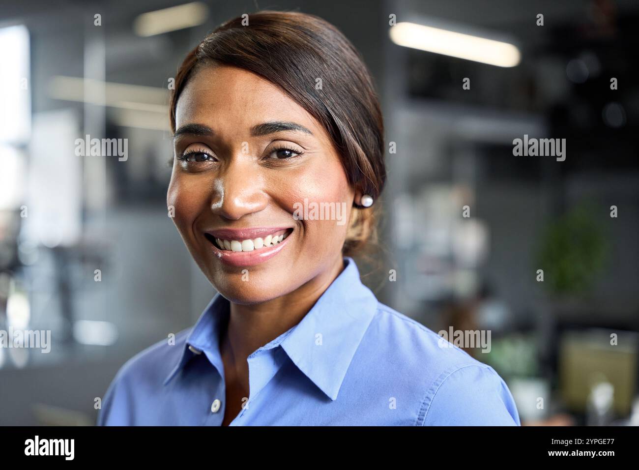 Giovane donna d'affari africana sicura di sé sorridente in ufficio, ritratto alla testa. Foto Stock