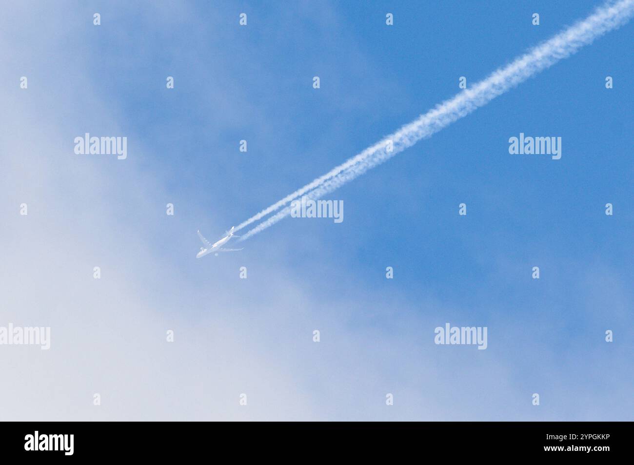 L'aereo da trasporto fa la linea molto forte di tracce chimiche sul cielo blu. Teoria della cospirazione. Foto Stock