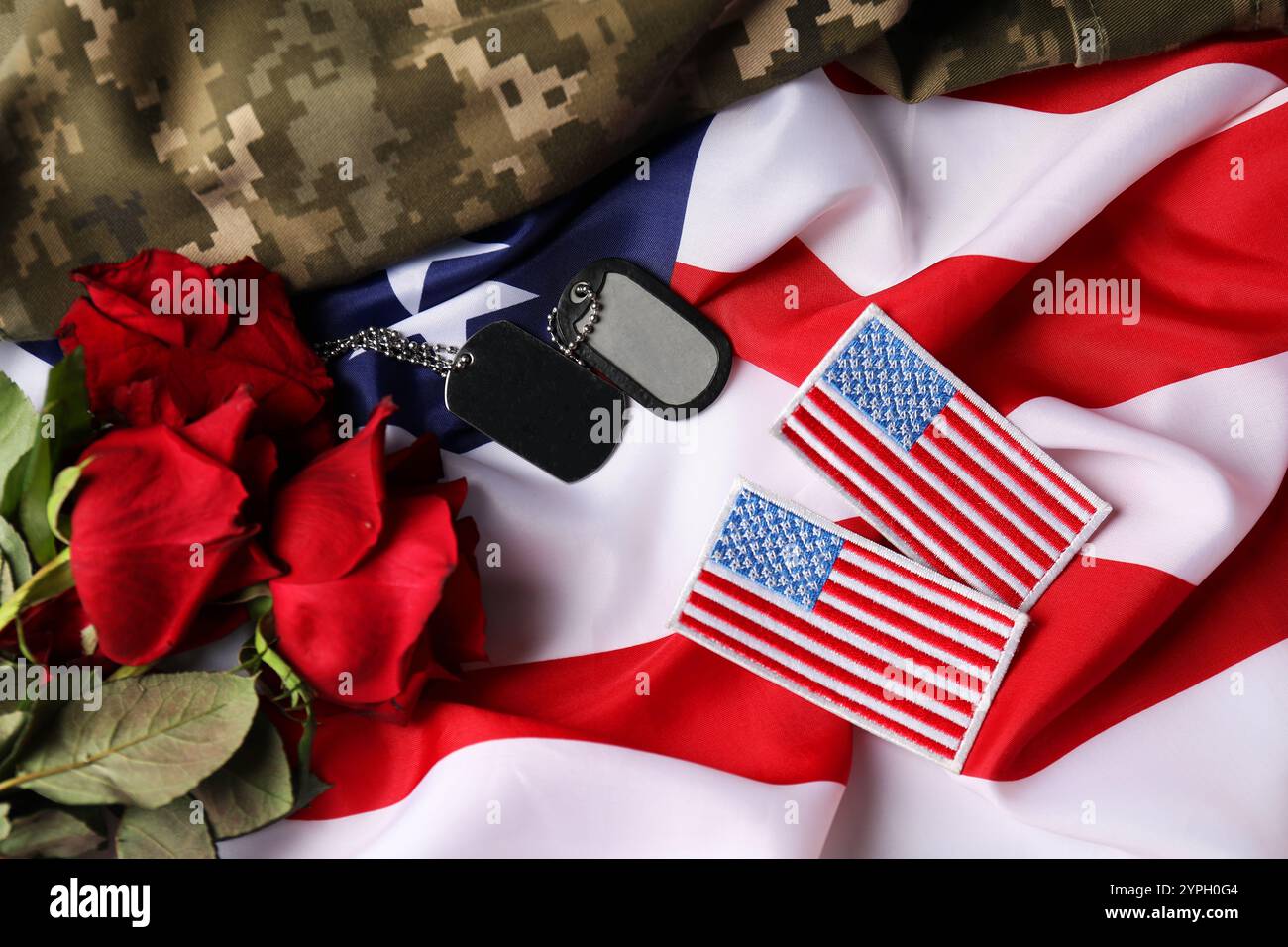 Giornata dei veterani. Toppe, gettoni, rose e uniformi militari statunitensi sulla bandiera americana, piatti Foto Stock