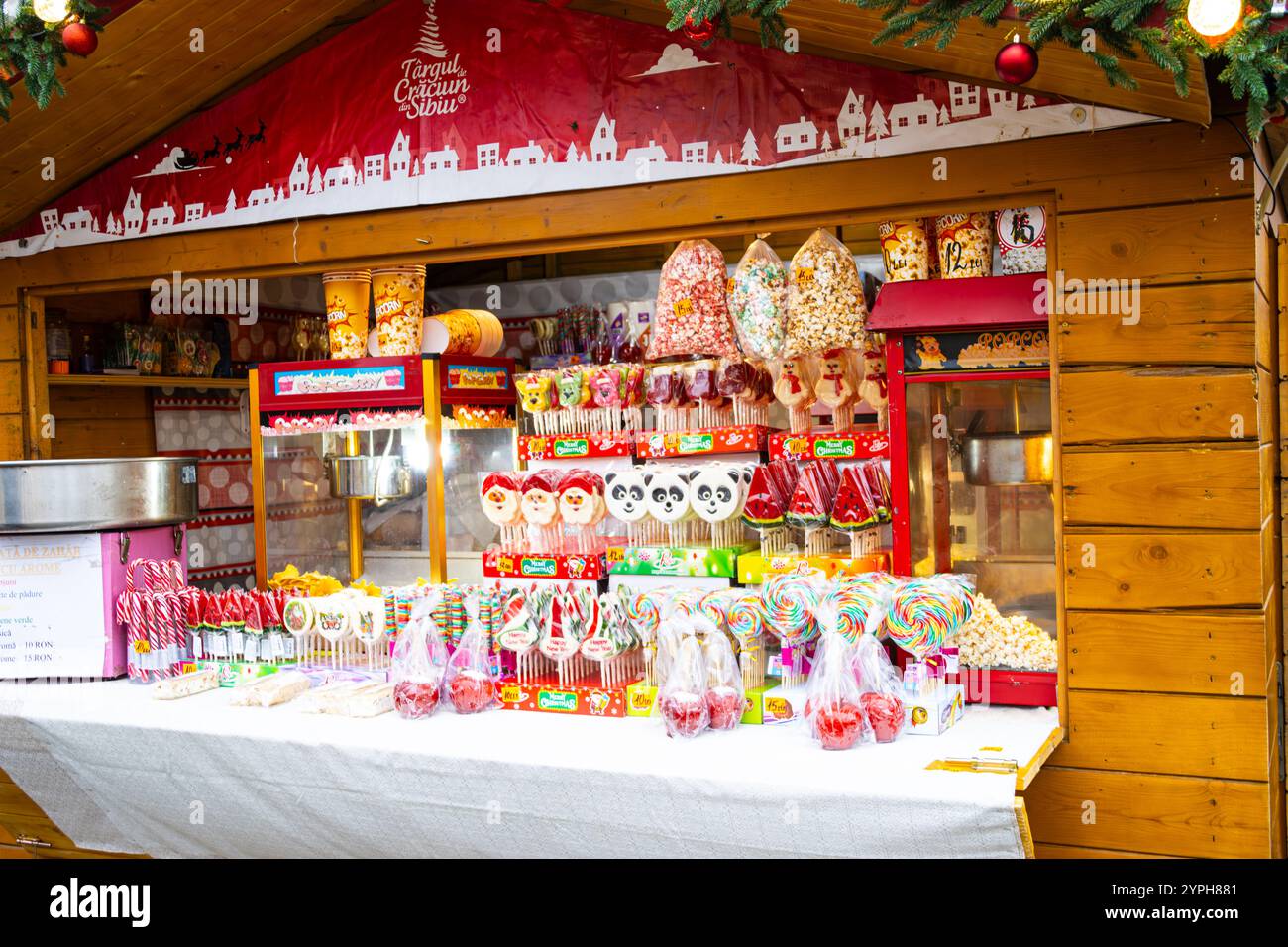 Dolci natalizi fatti in casa come pan di zenzero, lecca lecca, canne di caramelle e pop corn in vendita presso un chiosco presso il mercato di Natale di Sibiu, Romania Foto Stock