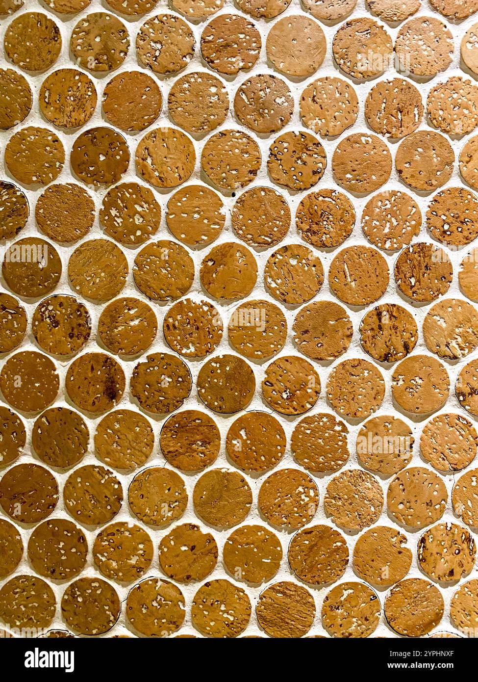 Un muro piastrellato con piccole piastrelle rotonde di terracotta colorate in un motivo ricorrente Foto Stock