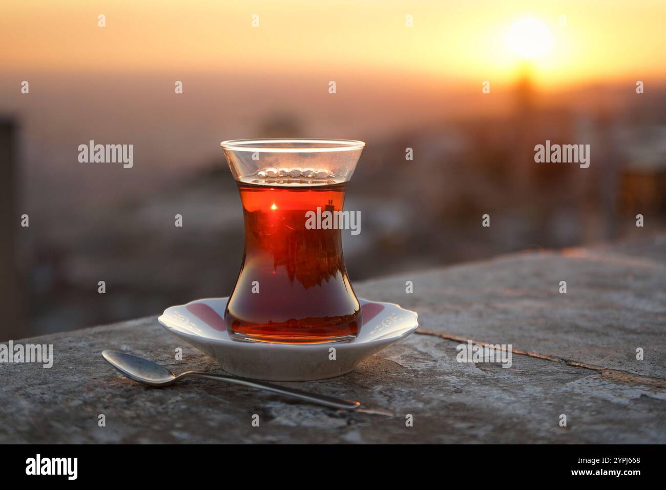Tradizionale bicchiere di tè nero turco a forma di tulipano al tramonto, Mardin, Türkiye Foto Stock