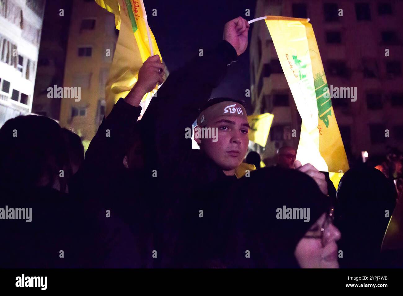 Beirut, Libano. 30 novembre 2024. Un sostenitore tiene una bandiera durante un memoriale per l'ex leader degli Hezbollah Hassan Nasrallah, nel luogo in cui è stato assassinato. Hassan Nasrallah è stato ucciso il 27 settembre 2024, quando Israele ha sganciato bombe "bunker buster", livellando più blocchi di appartamenti nella periferia meridionale di Beirut. (Foto di Sally Hayden/SOPA Images/Sipa USA) credito: SIPA USA/Alamy Live News Foto Stock