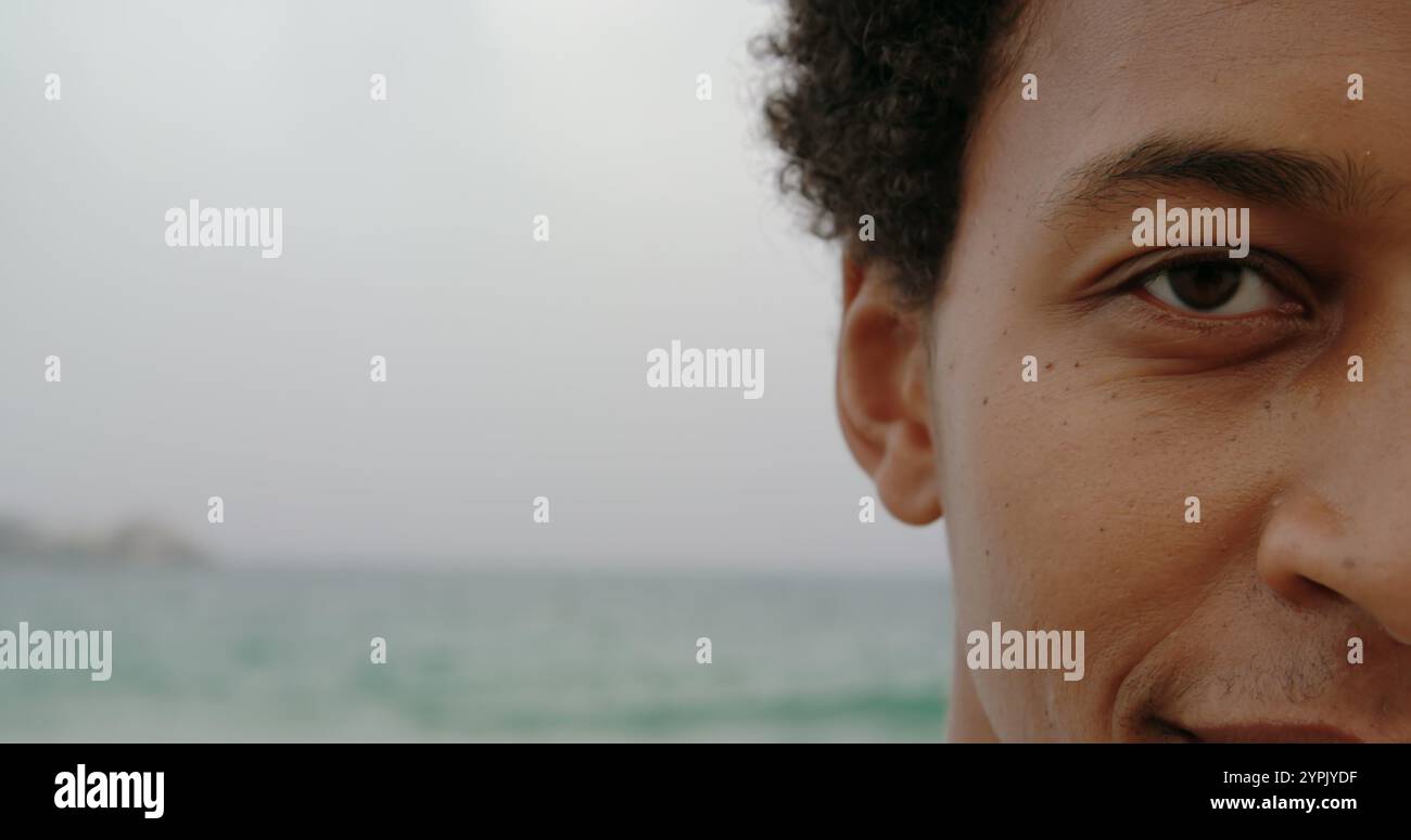 Primo piano di un uomo afroamericano in piedi sulla spiaggia Foto Stock