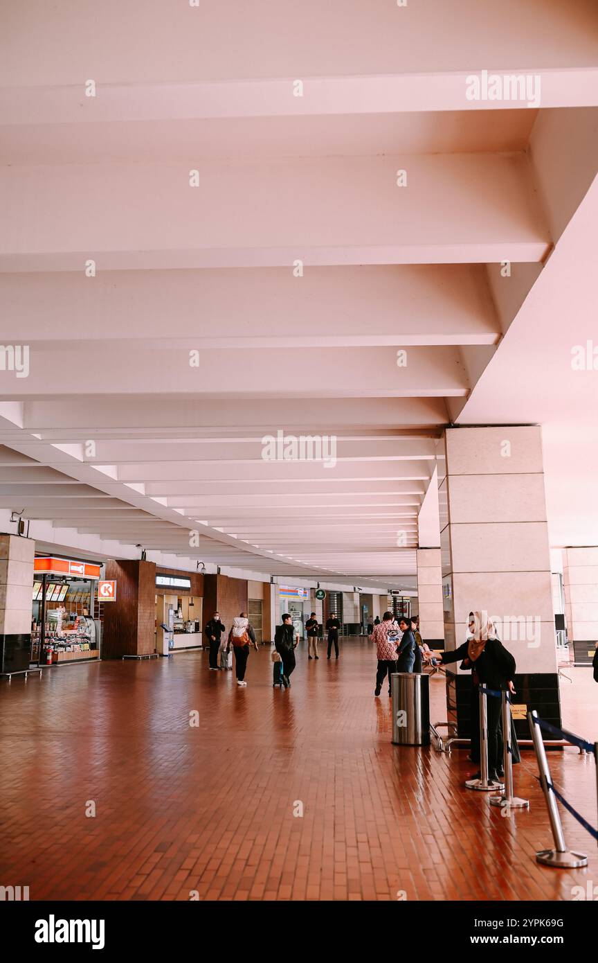 Gate 2 di un aeroporto internazionale, caratterizzato da un'architettura moderna e un'atmosfera vivace, accoglie viaggiatori da tutto il mondo Foto Stock