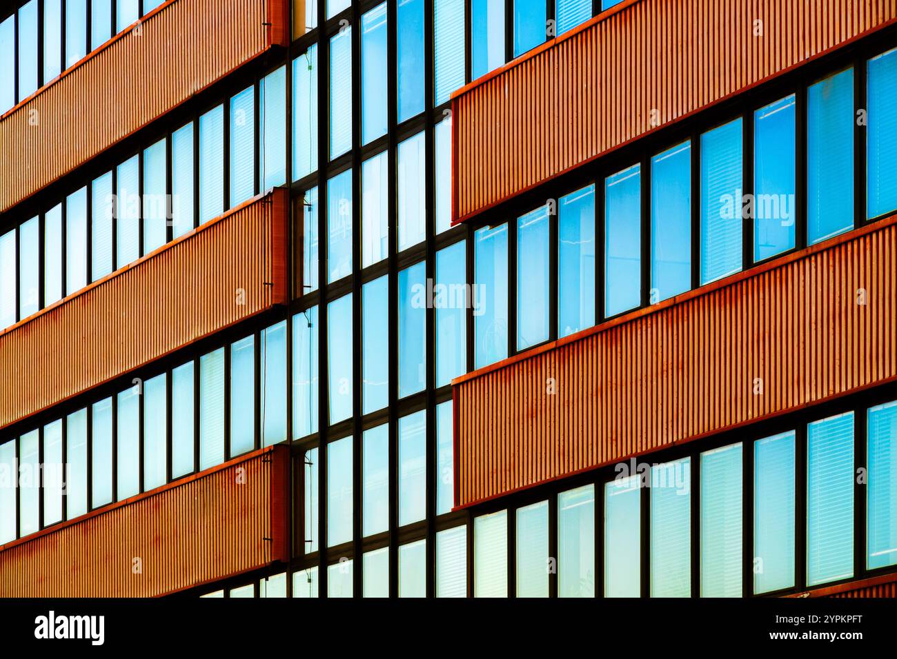 Edificio moderno con pannelli metallici verticali e finestre di vetro riflettente Foto Stock