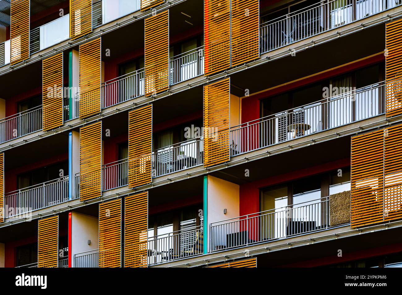 Moderno edificio di appartamenti con vibranti pannelli di legno giallo e spaziosi balconi Foto Stock