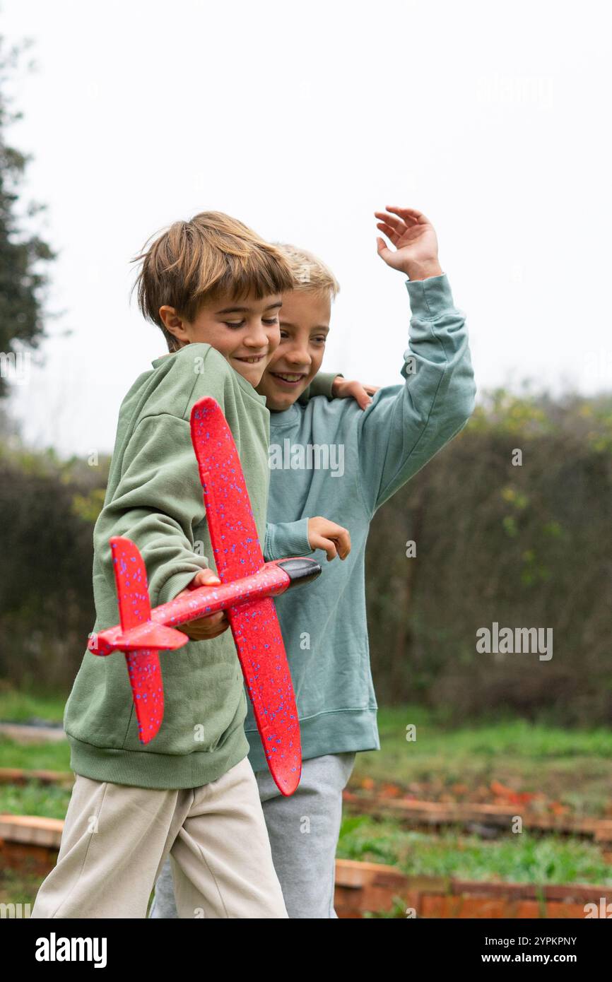 Due bambini felici che giocano con un aereo all'aperto Foto Stock