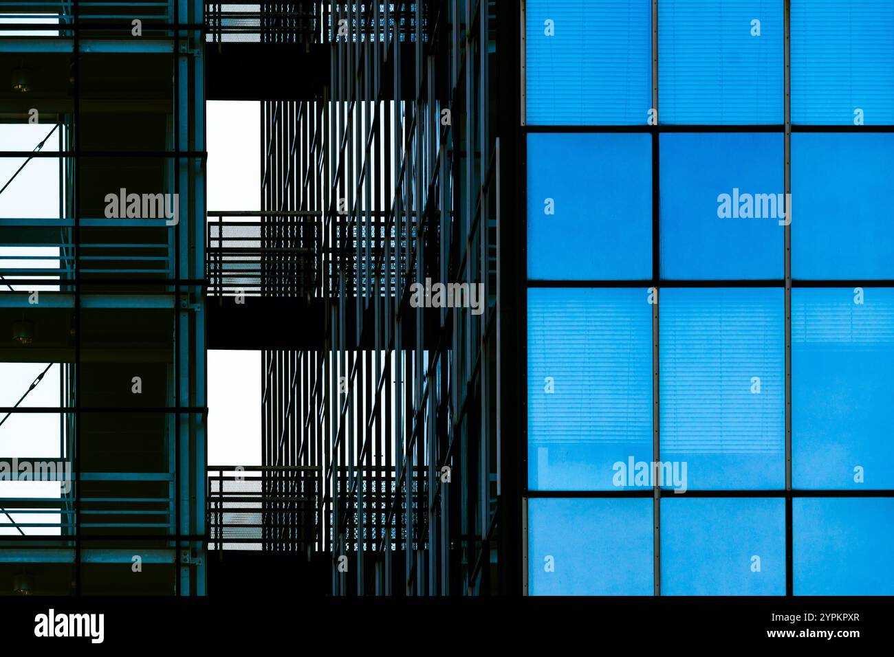 Moderna facciata in vetro con scale interne con motivi simmetrici e riflessi Foto Stock