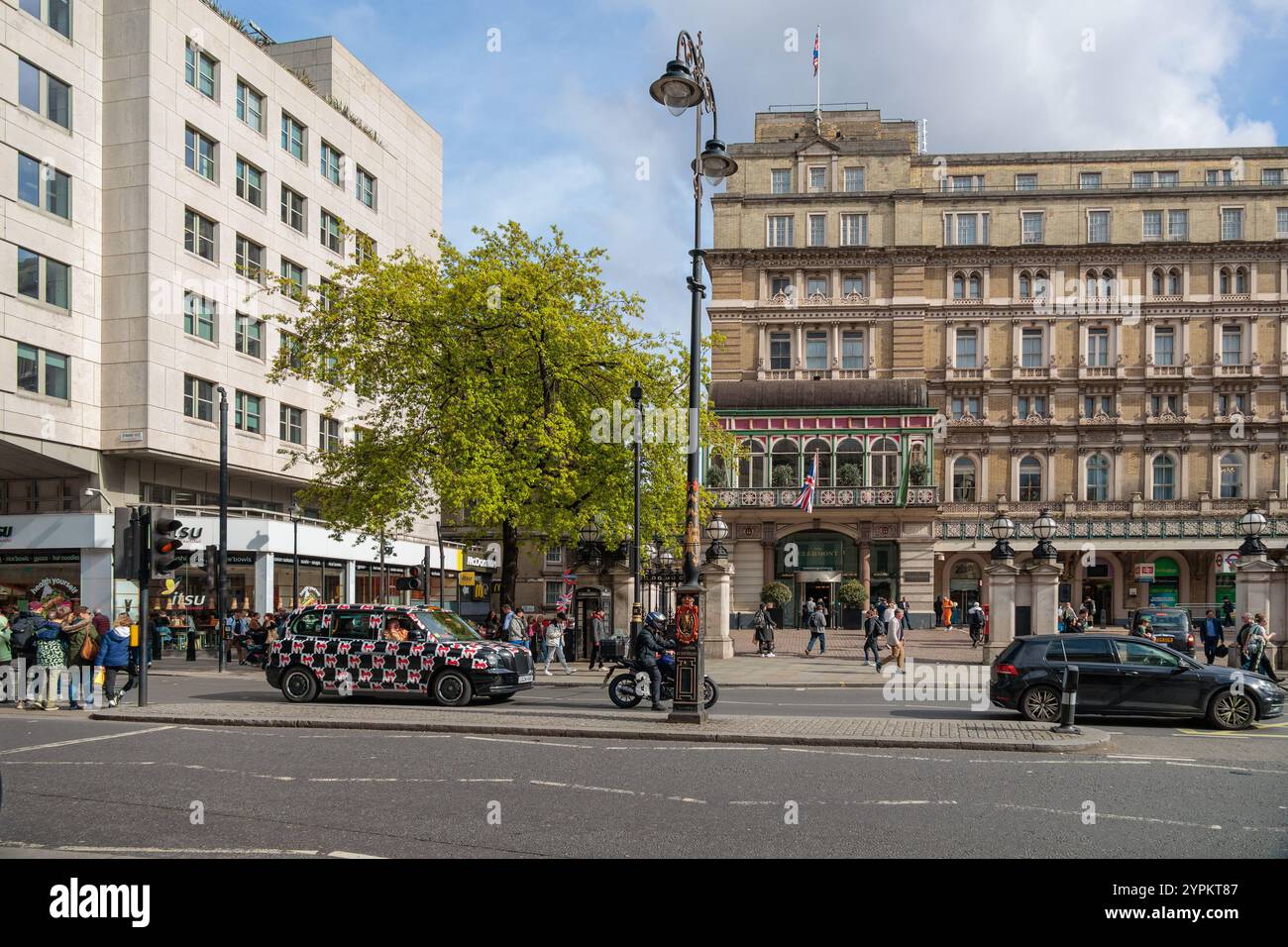 La facciata dello storico Clermont Hotel contrasta con i moderni edifici commerciali in London Street, con taxi decorati e vivace vita di strada Foto Stock