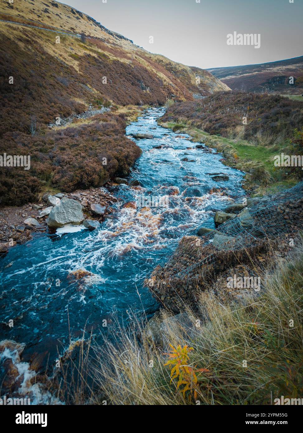 Idilliaca valle del fiume con Rolling Hills e vegetazione autunnale sotto un cielo luminoso Foto Stock