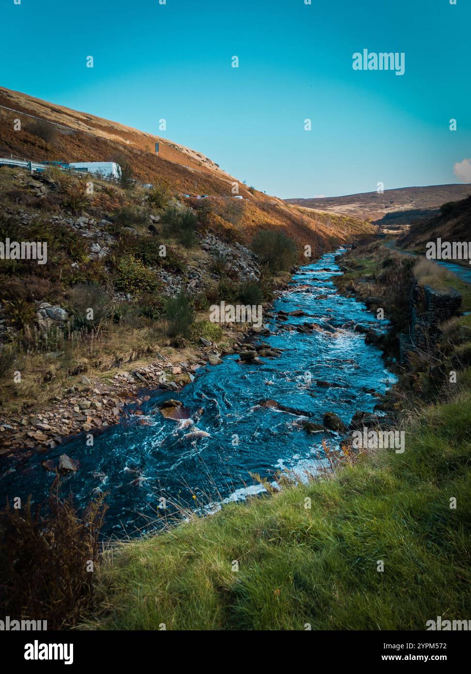 Idilliaca valle del fiume con Rolling Hills e vegetazione autunnale sotto un cielo luminoso Foto Stock