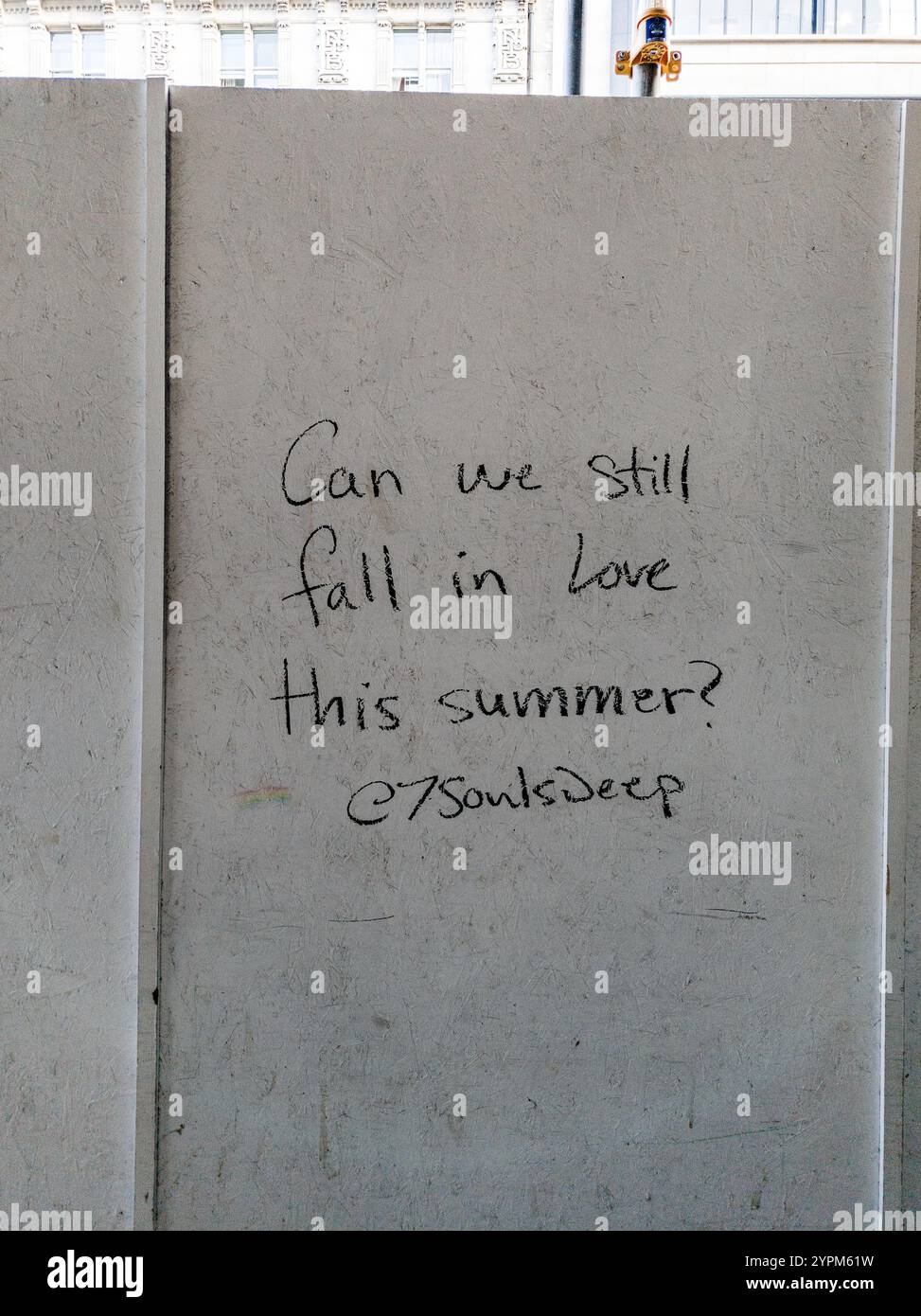 Messaggio scritto a mano su Urban Wall che chiede "possiamo ancora innamorarci questa estate?" In un ambiente urbano Foto Stock