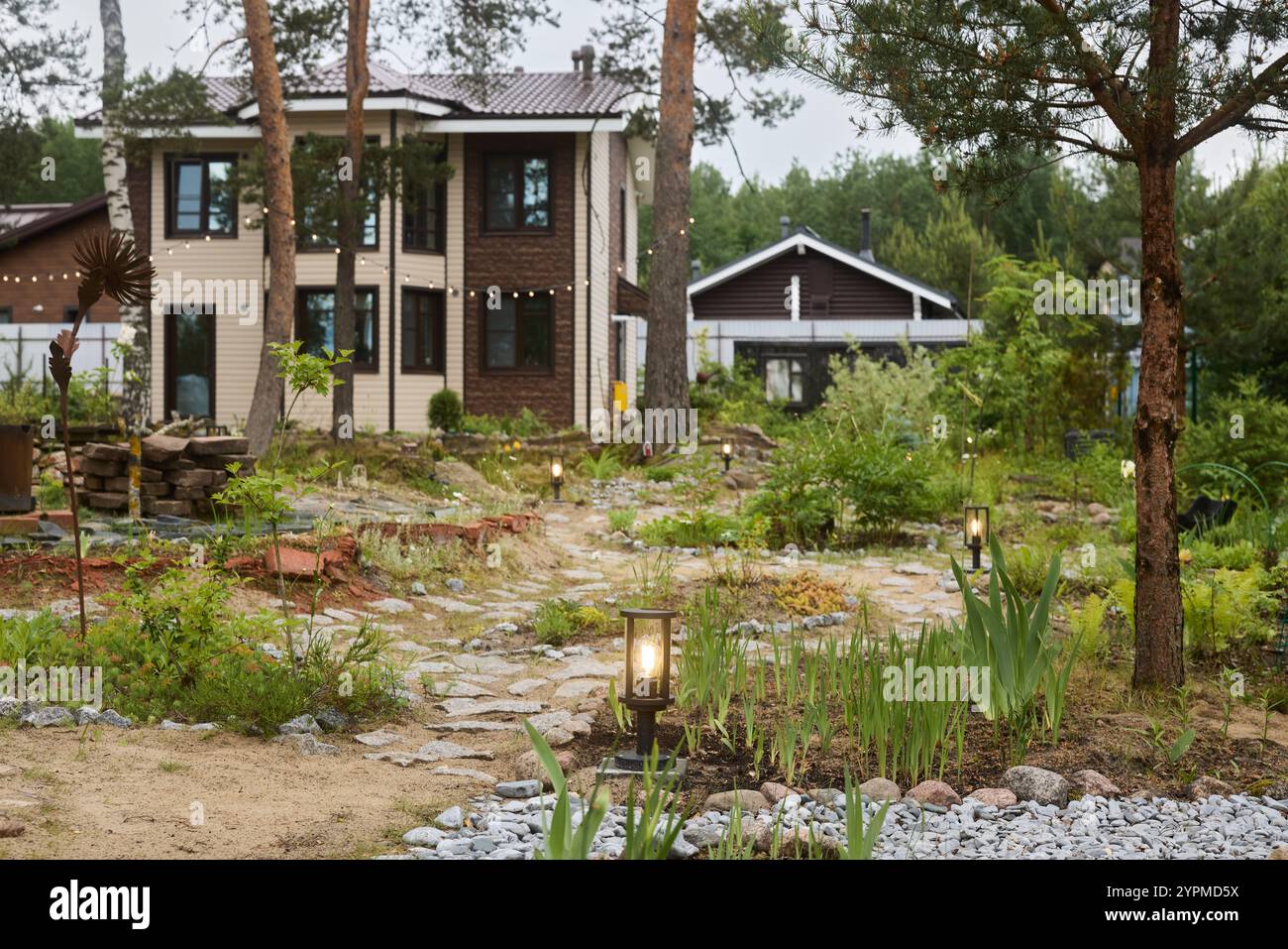 Splendida e splendida casa moderna circondata da un giardino lussureggiante e splendido e dalla natura Foto Stock