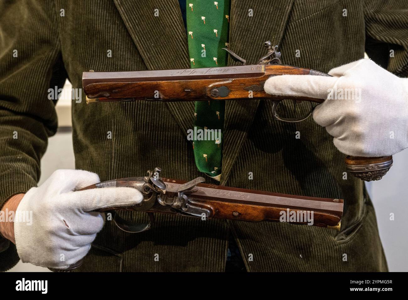 Londra, Regno Unito. Dicembre 2024. Un membro dello staff presenta un paio di pistole da ufficiale francese di Boutet, Versailles, Parigi marchi per il 1798-1809, stimate £ 10.000 - £ 14.000, in anteprima della vendita fine Antique Arms, Armour & Militaria alle aste Olympia di Kensington Olympia. I lotti saranno venduti il 4 dicembre. Crediti: Stephen Chung / Alamy Live News Foto Stock