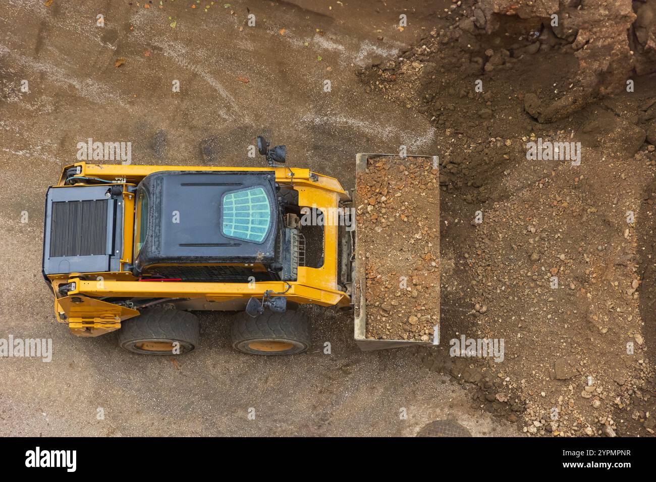 Il potente bulldozer o caricatore sposta la terra nel cantiere. Una macchina di movimento terra sta livellando il sito. Attrezzature pesanti da costruzione per e. Foto Stock