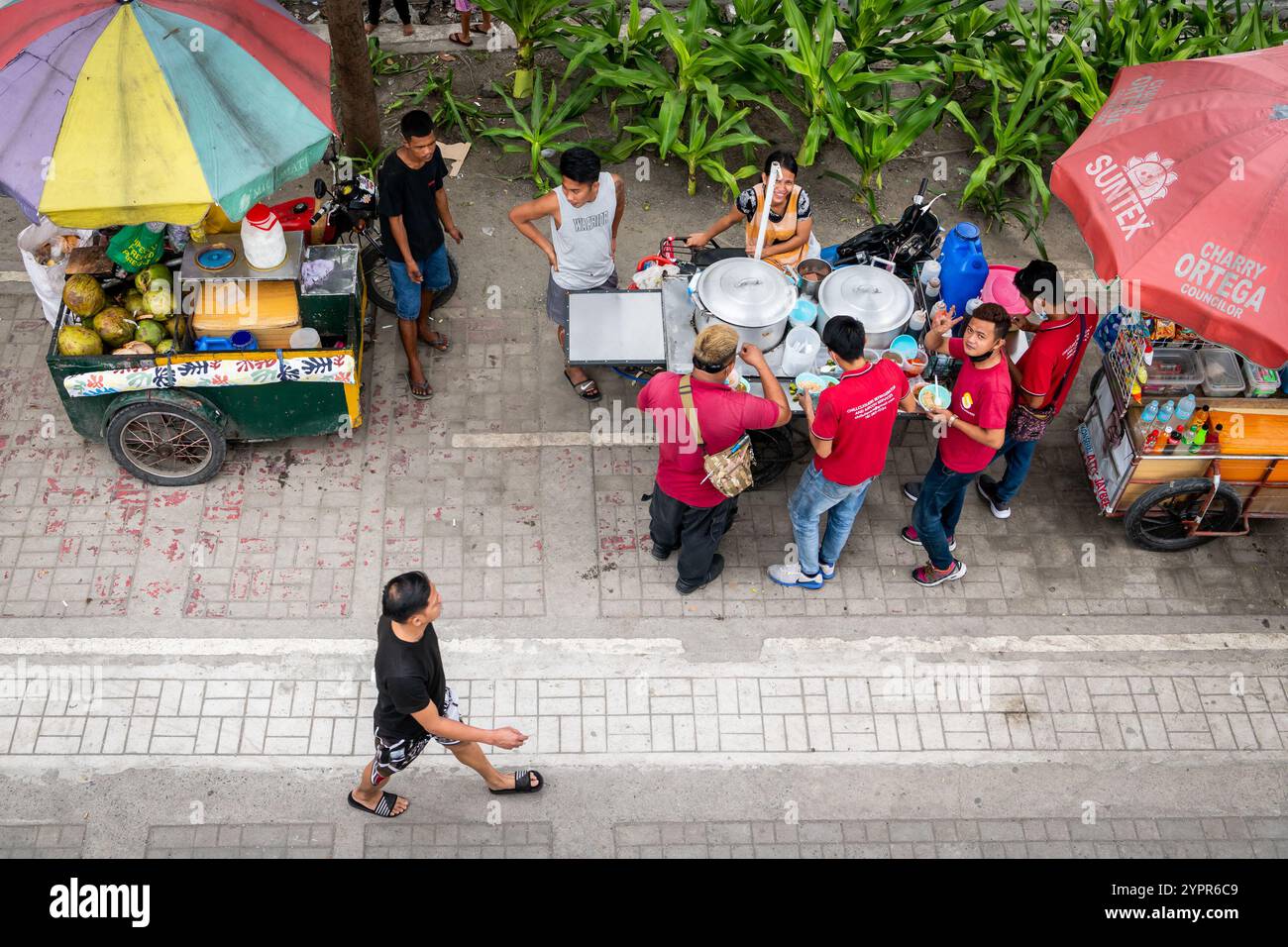 I pedoni si fanno strada lungo la baia di Manila, nel quartiere Ermita di Manila, nelle Filippine. Foto Stock
