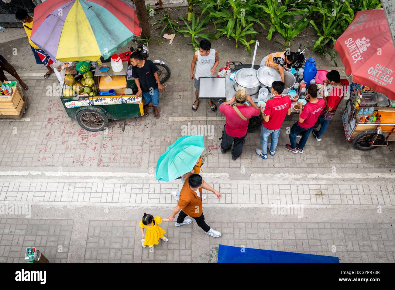 I pedoni si fanno strada lungo la baia di Manila, nel quartiere Ermita di Manila, nelle Filippine. Foto Stock