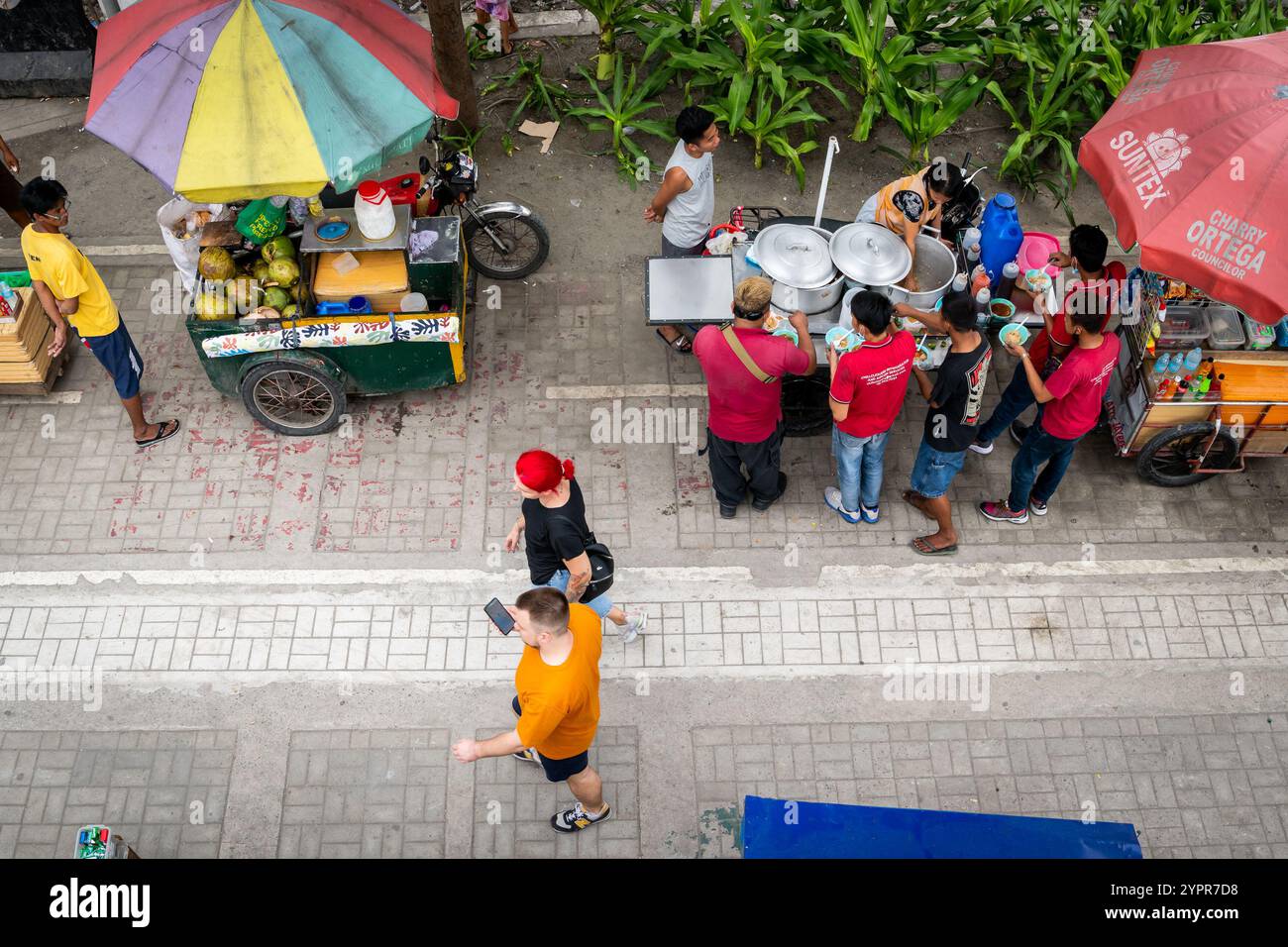 I pedoni si fanno strada lungo la baia di Manila, nel quartiere Ermita di Manila, nelle Filippine. Foto Stock