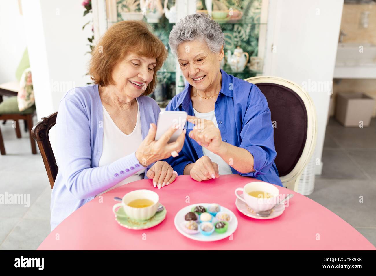 Due donne anziane si godono il dessert e condividono i ricordi in un bar Foto Stock