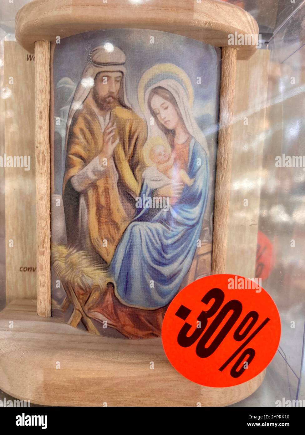 Una foto di Maria e Giuseppe con il bambino Gesù Cristo in un negozio di souvenir a Roma, vicino al Vaticano, con un cartellino di vendita che dice il 30% di prezzo ridotto - Immagine stock catturata con smartphone