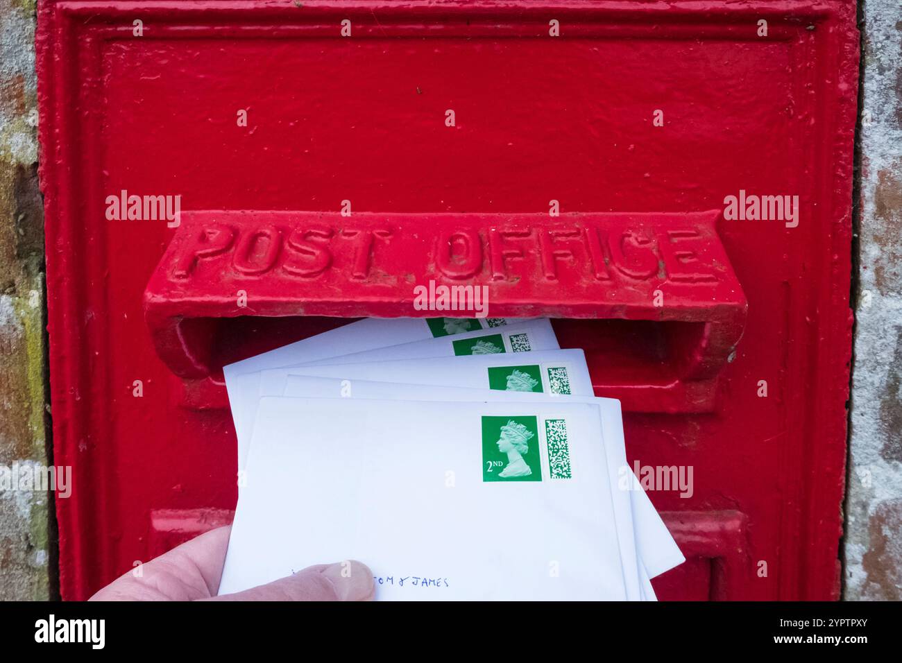 Pubblicazione di buste stampate di Natale di seconda classe in una casella postale del Regno Unito. Postare le cartoline di Natale. Foto Stock