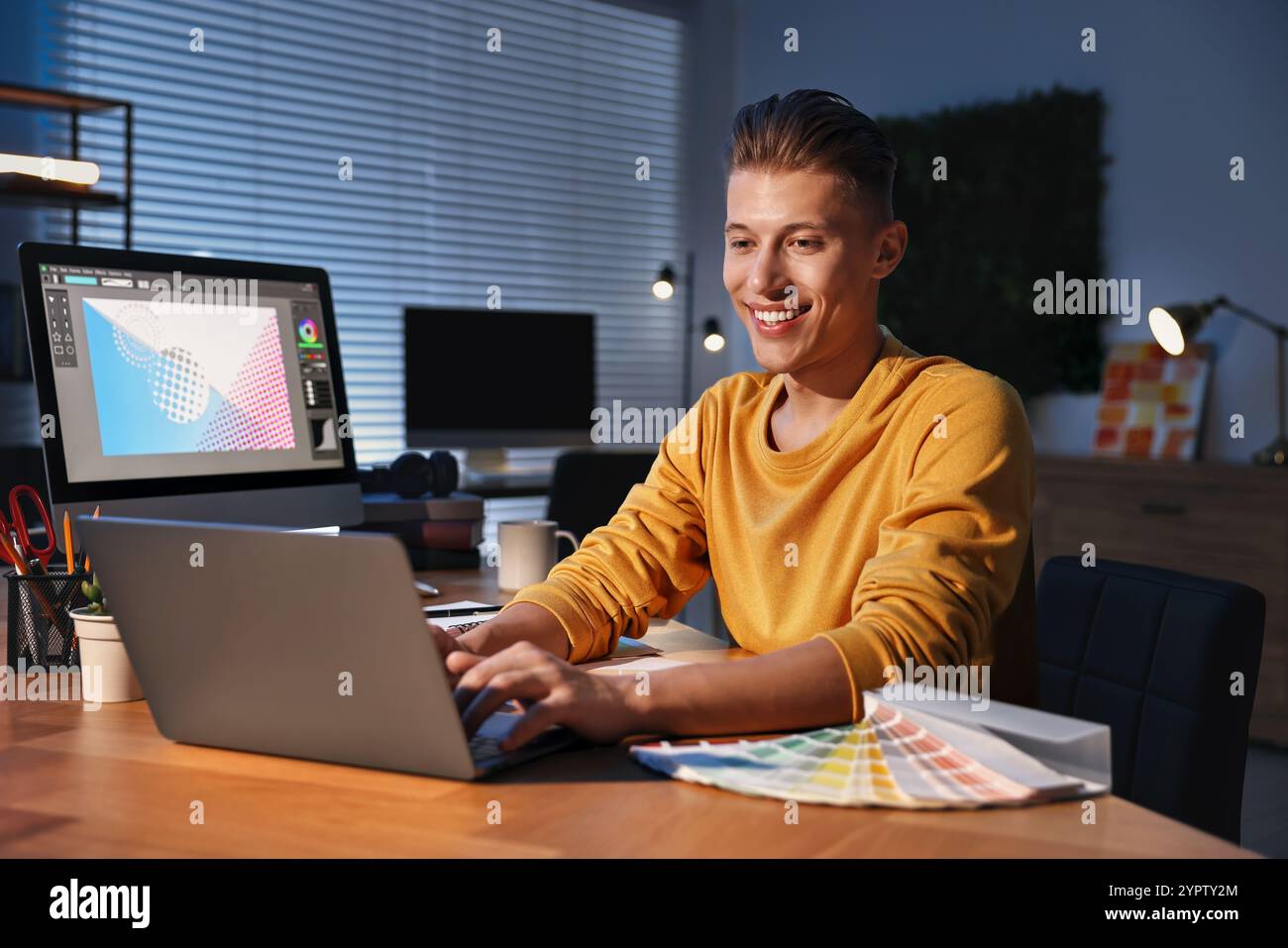 Designer che lavora su un notebook in interni di notte Foto Stock