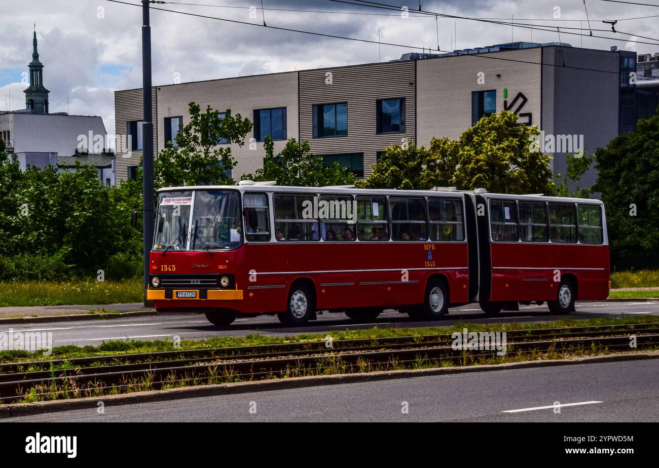 Un vecchio autobus guida accanto al moderno edificio. Foto Stock