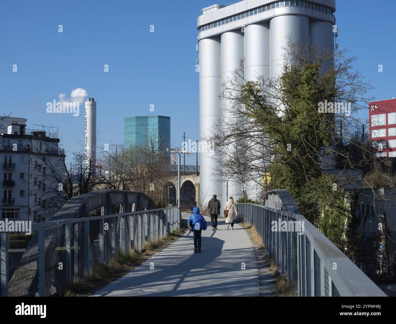 Una passeggiata lungo gli archi del viadotto di fronte a un camino fumante di un impianto di incenerimento e alla famosa torre principale. Situazione a Zurigo, S. Foto Stock