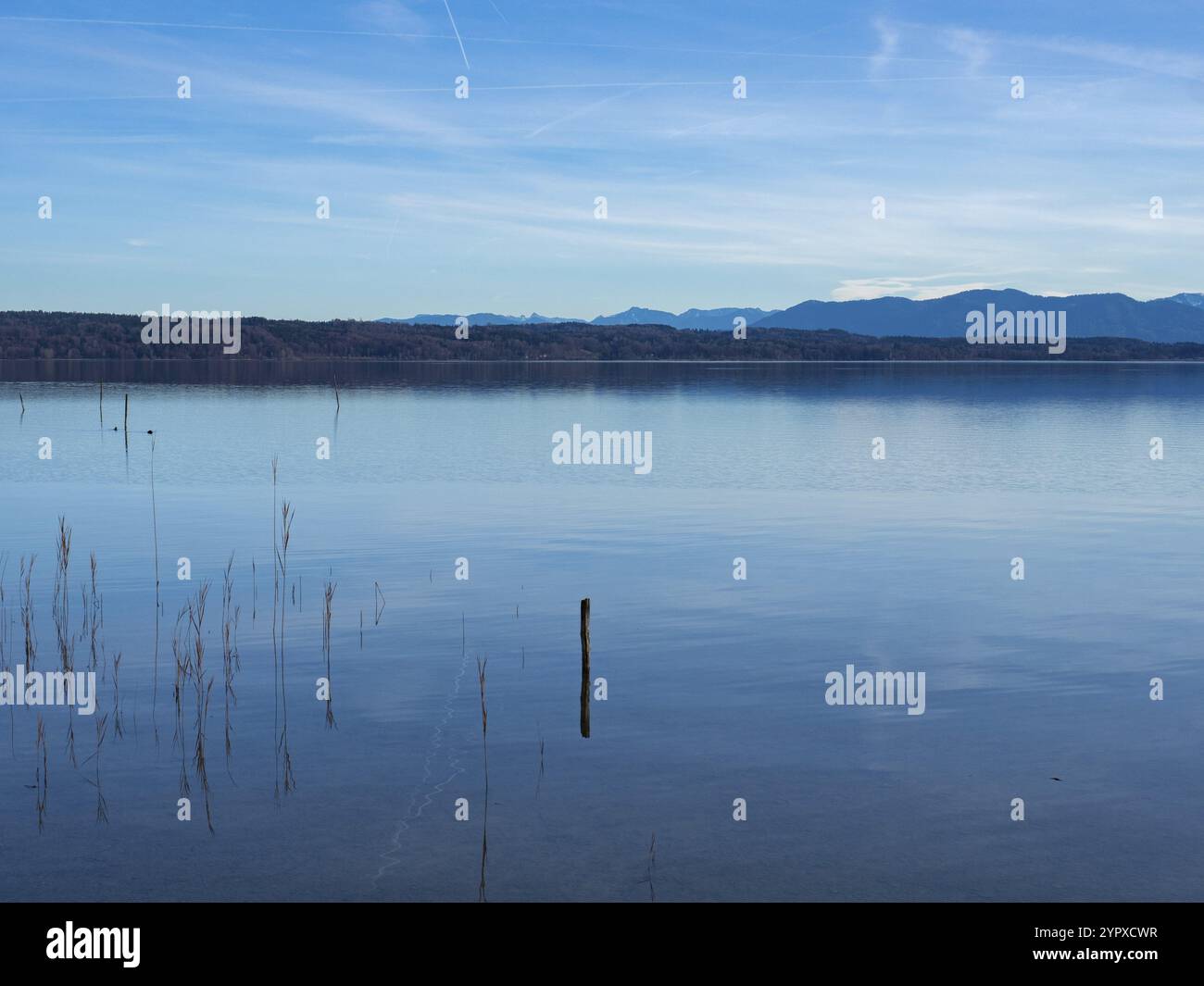 Splendido paesaggio sul lago Starnberger SEE, Germania: La superficie piatta del lago di fronte a foreste e alte vette alpine Foto Stock